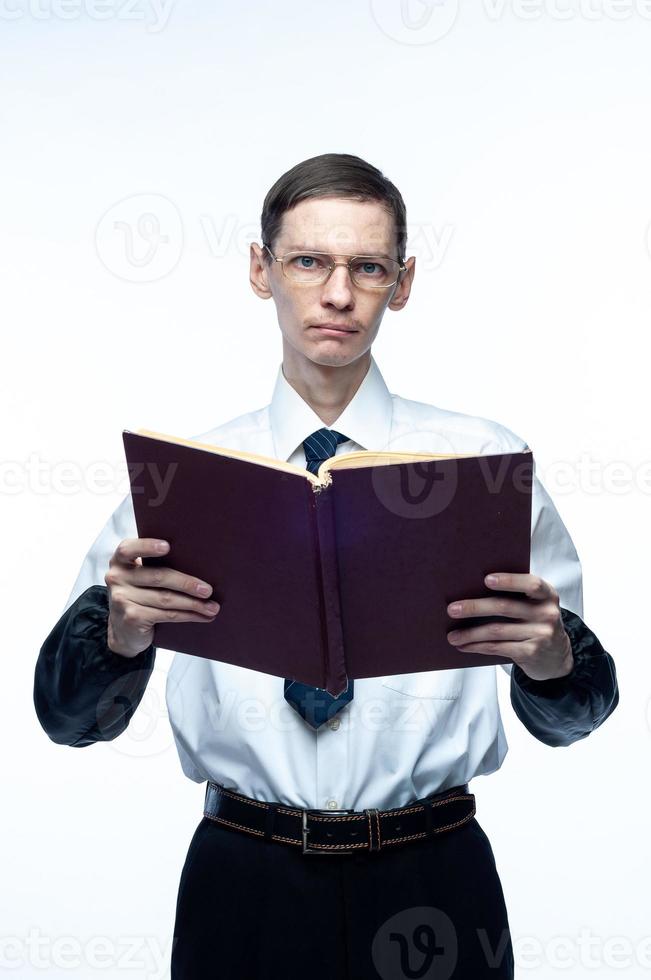 un homme d'affaires en cravate et lunettes avec un magazine dans ses mains sur un fond blanc et isolé photo