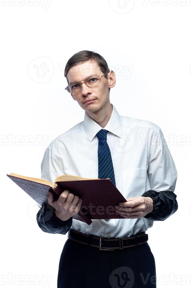 un homme d'affaires en cravate et lunettes avec un magazine dans ses mains sur un fond blanc et isolé photo