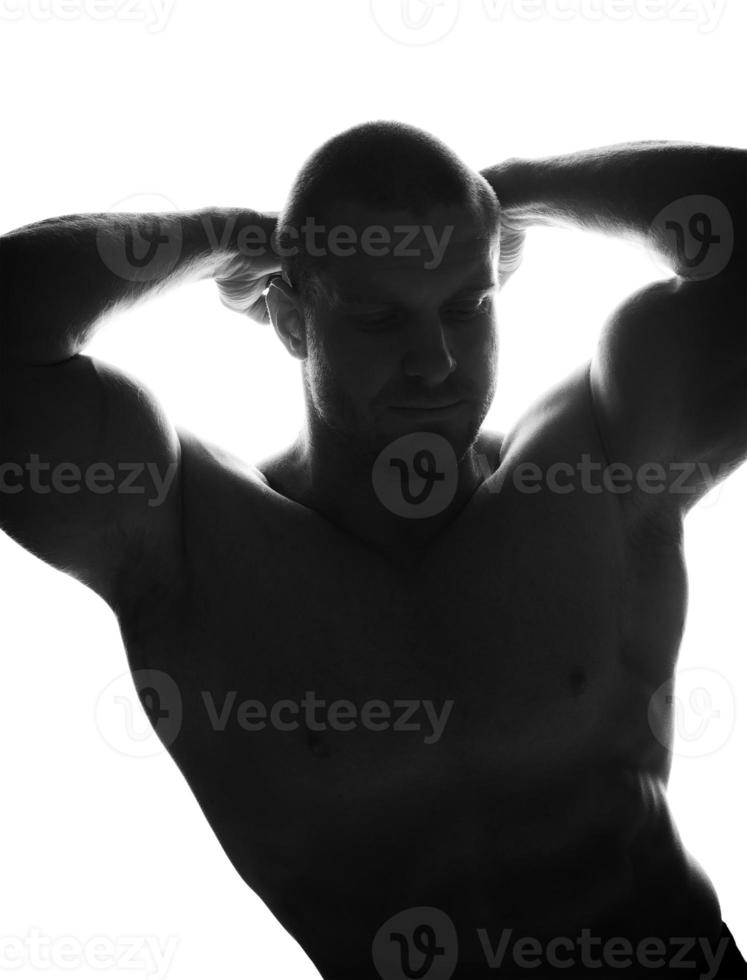 homme sportif debout sur un fond noir, faisant du sport photo