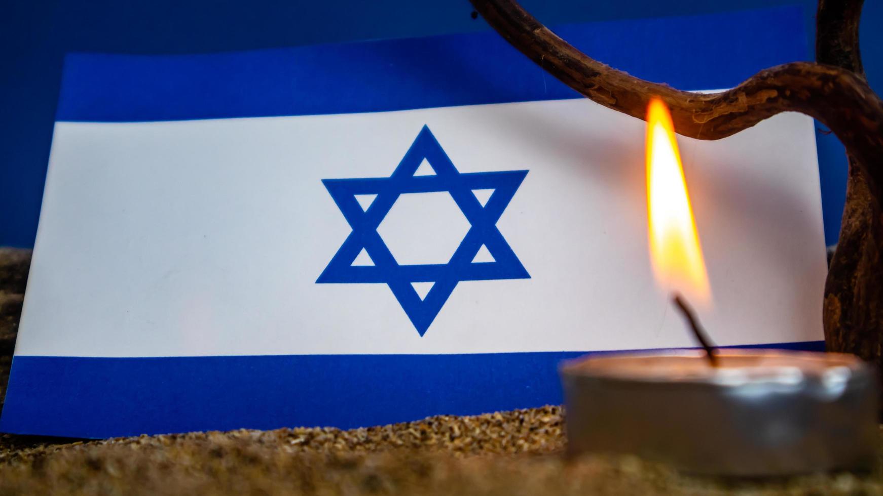 drapeau israélien et bougies allumées devant, jour de la mémoire de l'holocauste photo