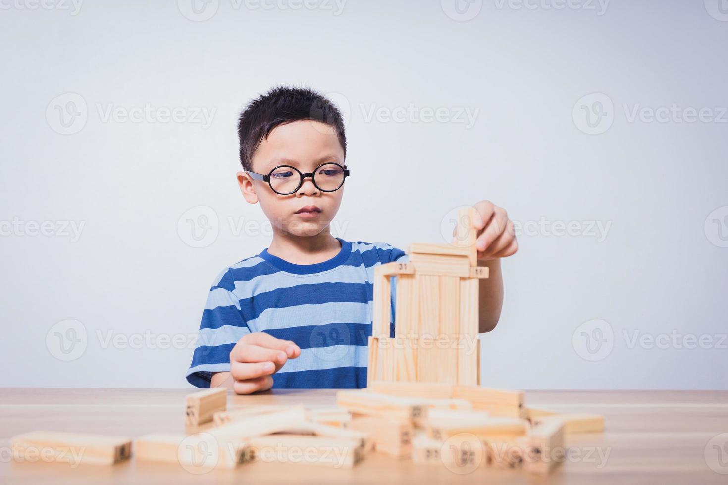 garçon asiatique jouant avec un puzzle en bois photo