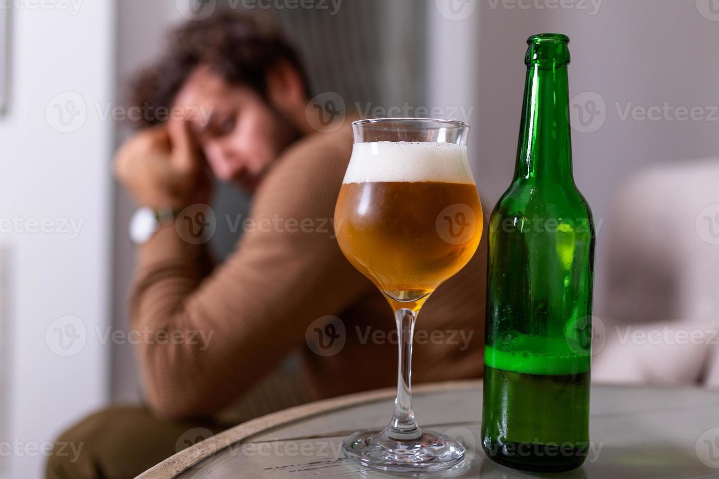 déprimé triste jeune homme accro se sentant mal de boire de la bière seul à la maison, stressé frustré buveur solitaire alcoolique souffre d'une dépendance à l'alcool ayant un problème, concept d'alcoolisme photo