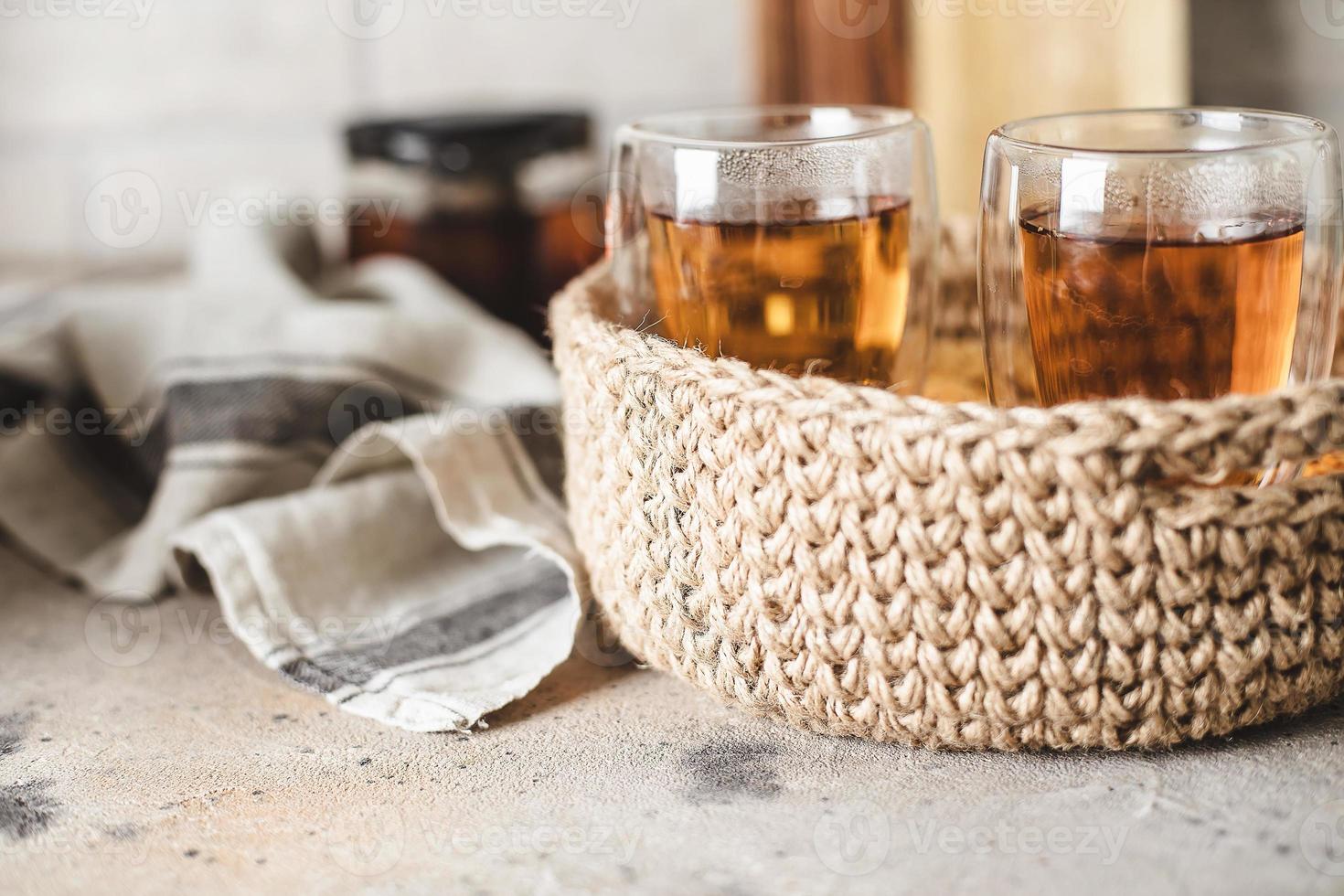 verre de thé chaud dans un panier de jute à l'intérieur de la maison. concept de petit-déjeuner photo