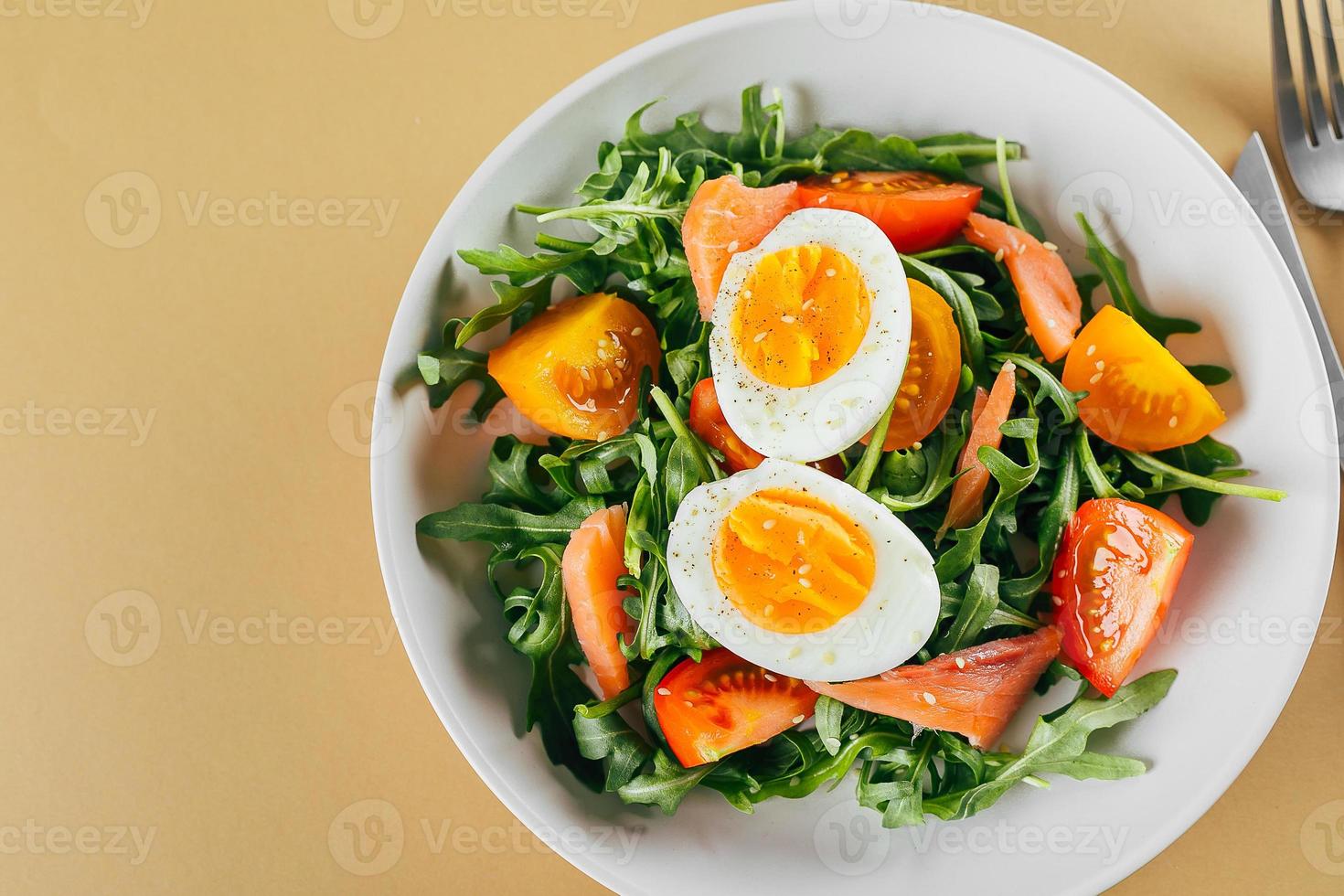 salade végétalienne saine de tomates fraîches, roquette, saumon, œuf et sésame. menu de régime céto. vue de dessus. photo