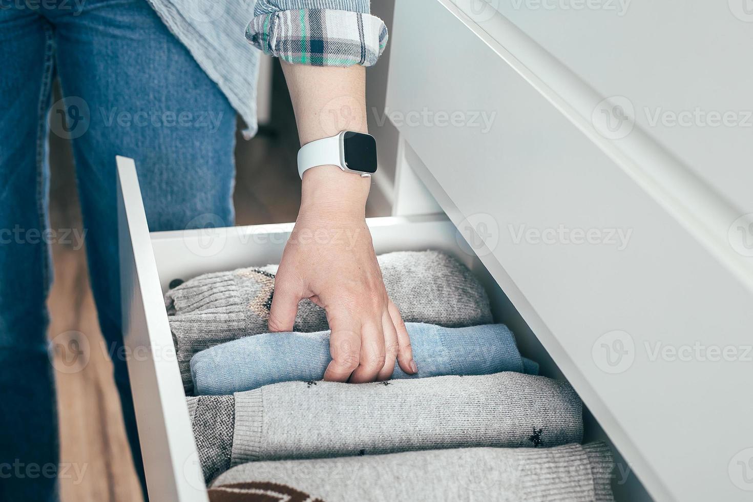 femme pliant des vêtements, organisant des trucs dans un tiroir. concept de stockage de vêtements, style de vie minimaliste photo