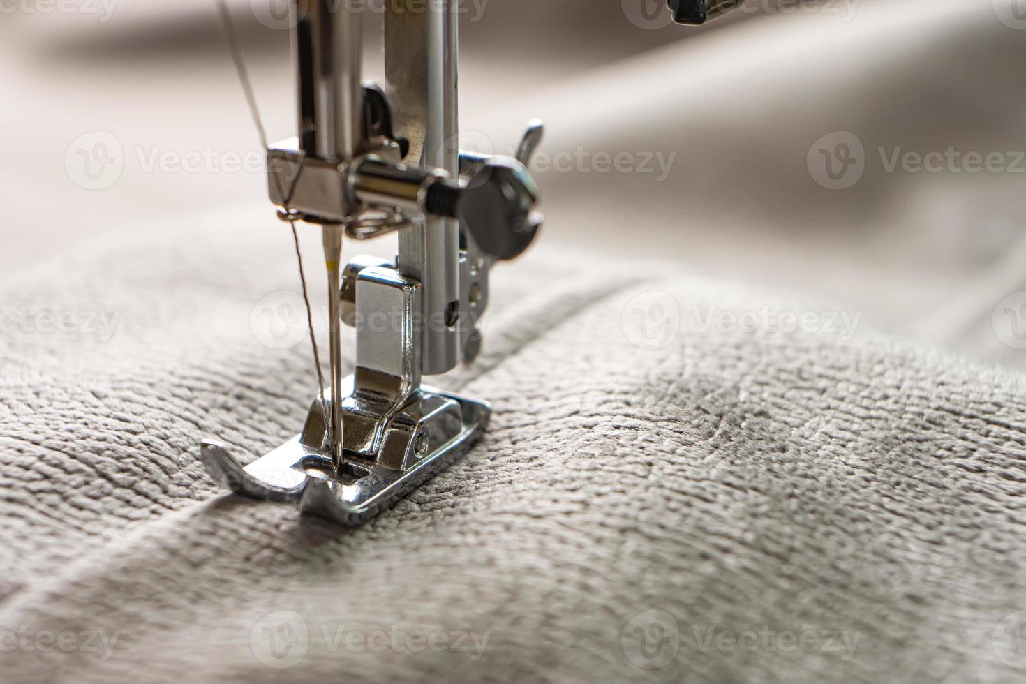 machine à coudre moderne et tissu gris. processus de couture, fait main, passe-temps, bricolage, entreprise, réparation photo