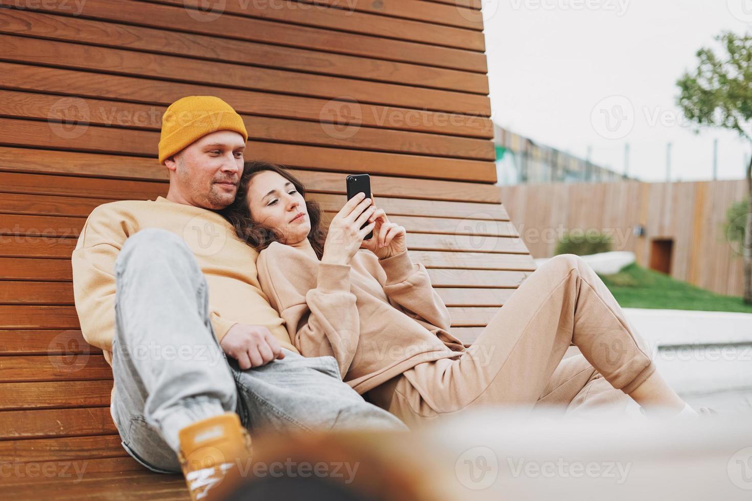 élégant jeune couple de famille amoureux des hipsters utilisant un téléphone portable dans le parc photo