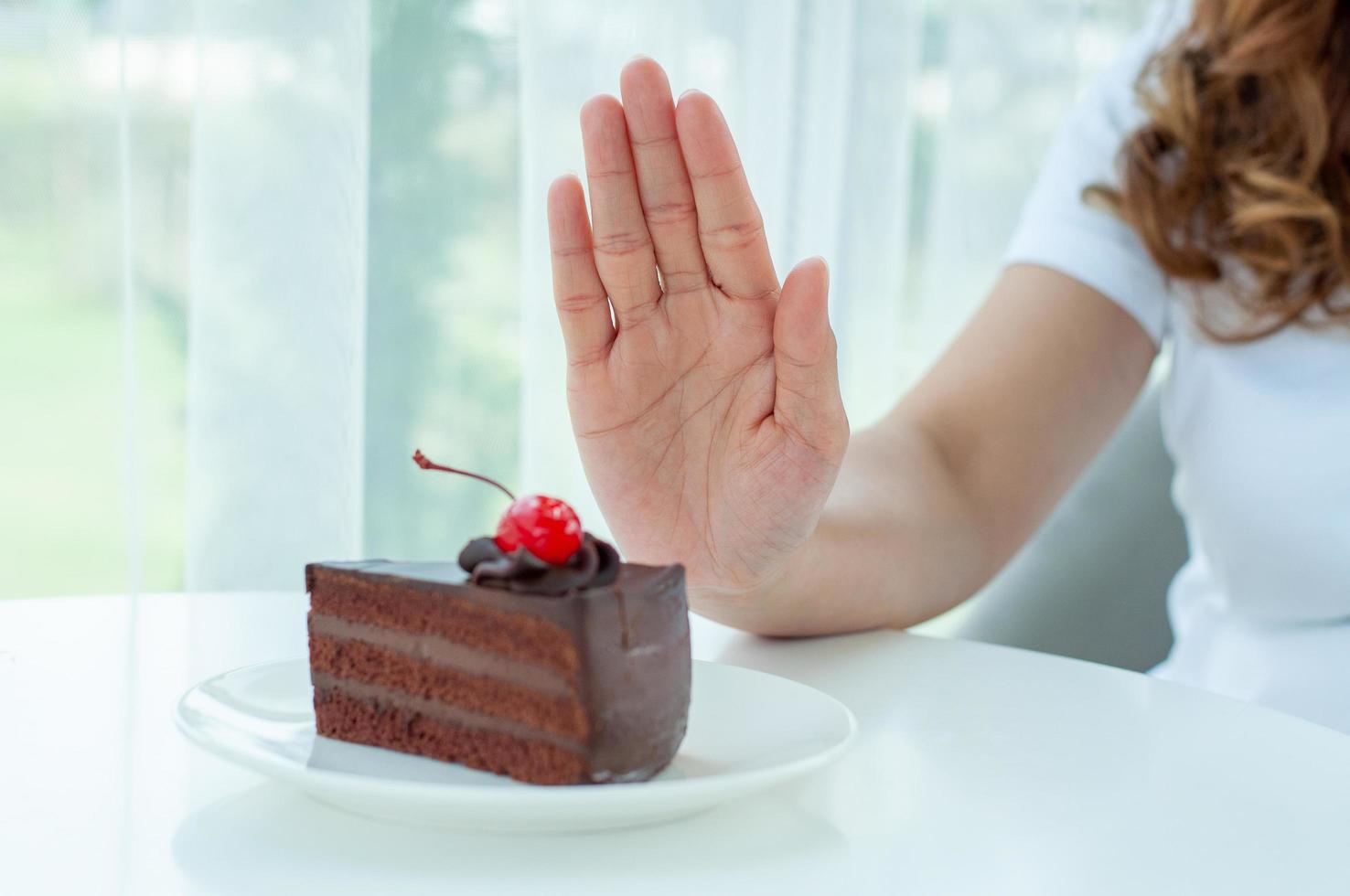 les femmes avaient l'habitude de pousser l'assiette à gâteau avec les gens. ne mangez pas de desserts pour perdre du poids. photo