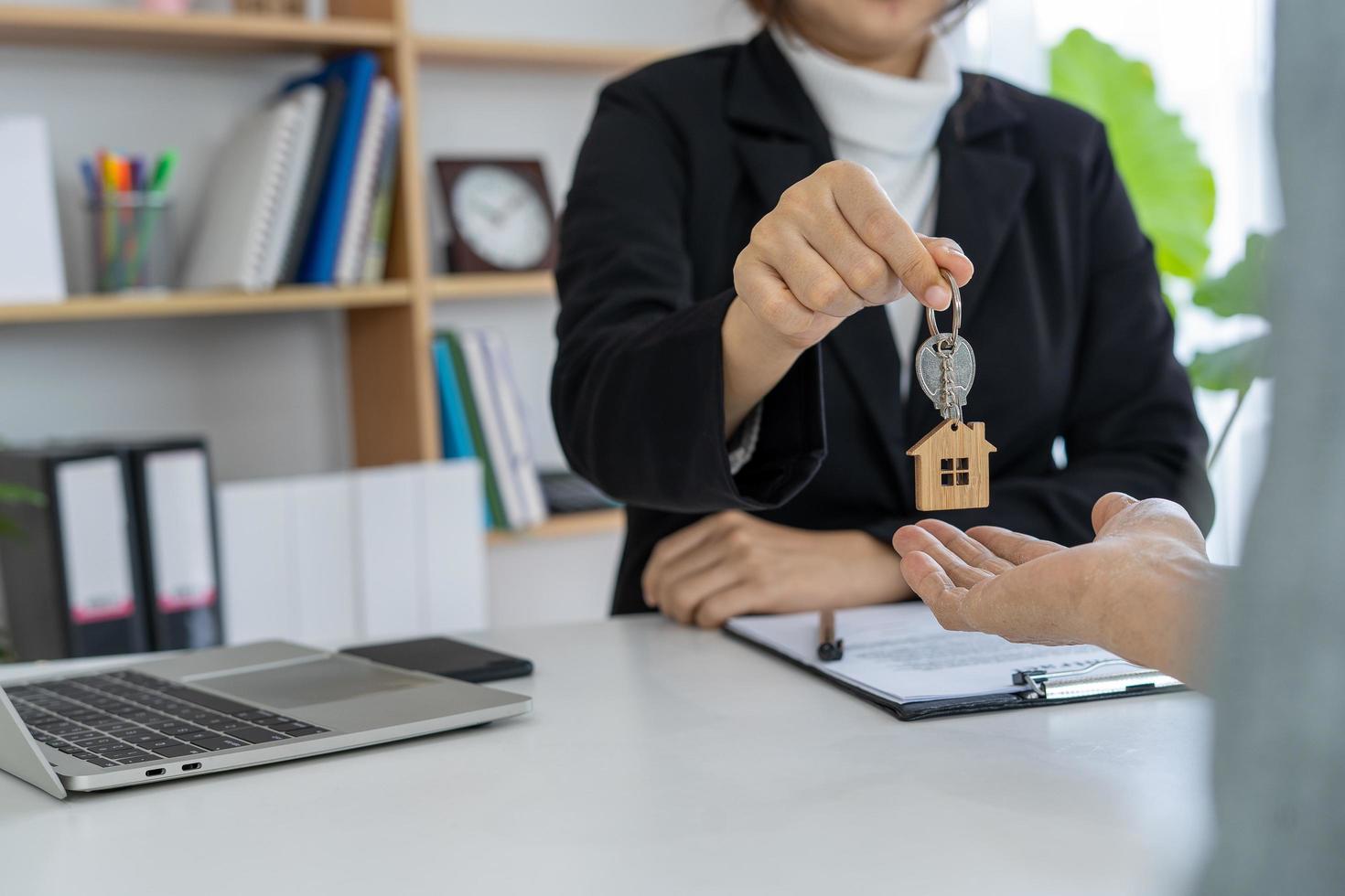 les agents immobiliers remettent la clé au propriétaire après accord d'achat-vente. photo