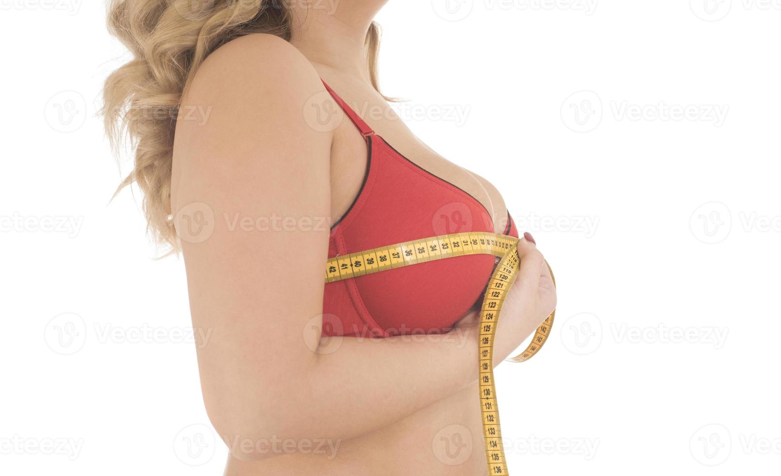 femme mesure sa poitrine avec un ruban à mesurer photo