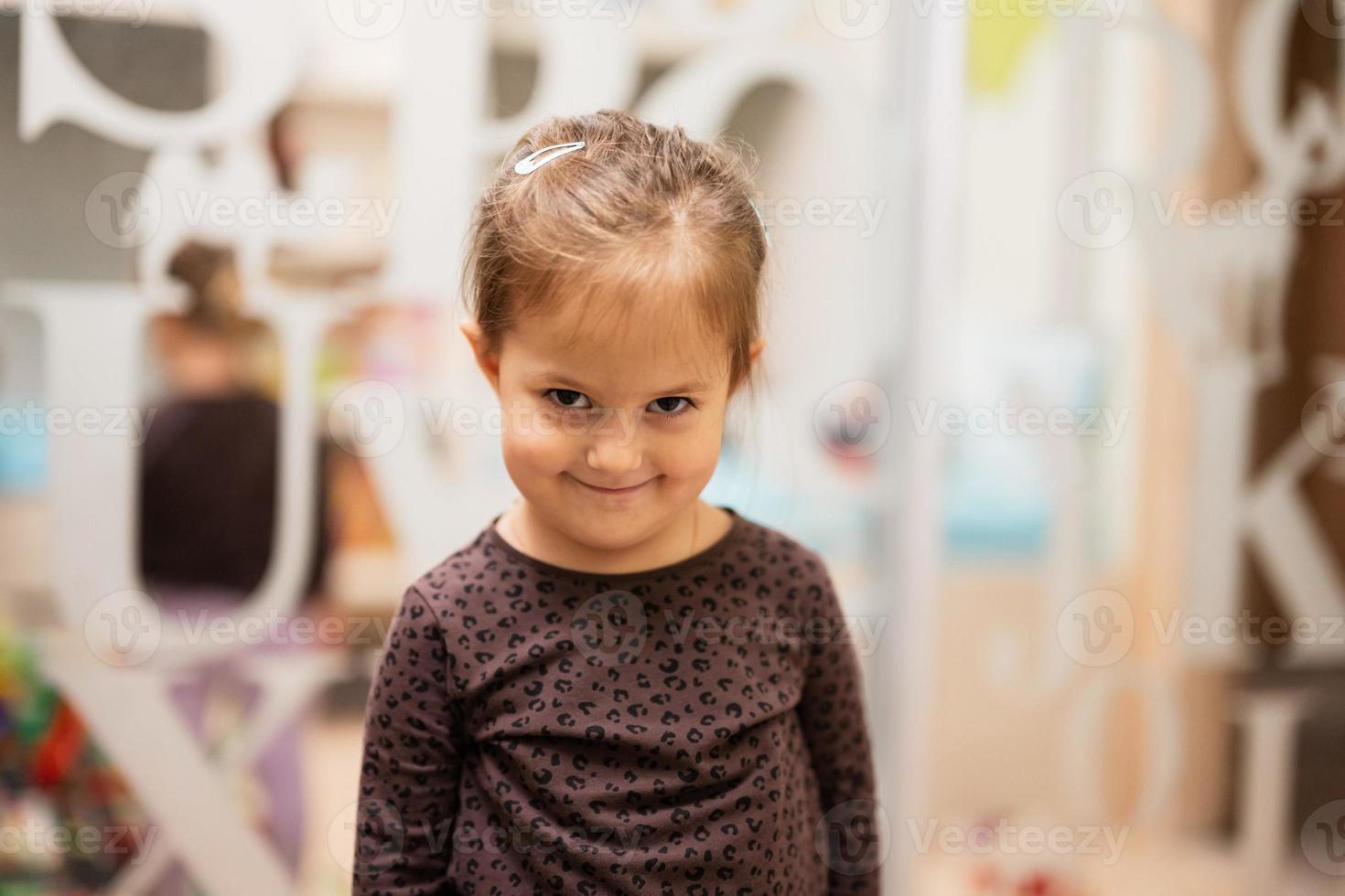 petite fille regardant la caméra dans la chambre des enfants. photo