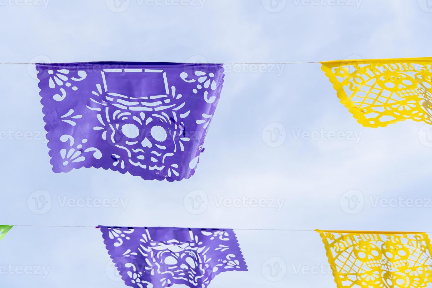 décoration jour des morts, papel picado violet et jaune, fond de ciel, mexique photo