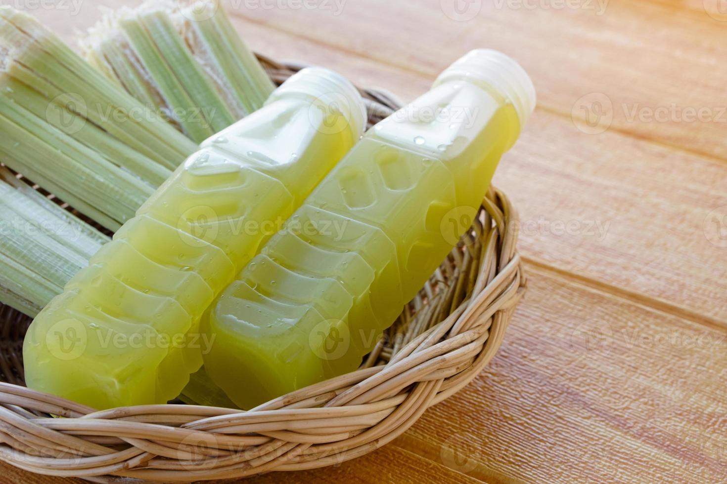 gros plan de bouteilles de jus de canne à sucre frais, mis sur le panier. concept, boisson naturelle saine à base de cultures agricoles. boissons maison, a des propriétés médicinales et à base de plantes photo