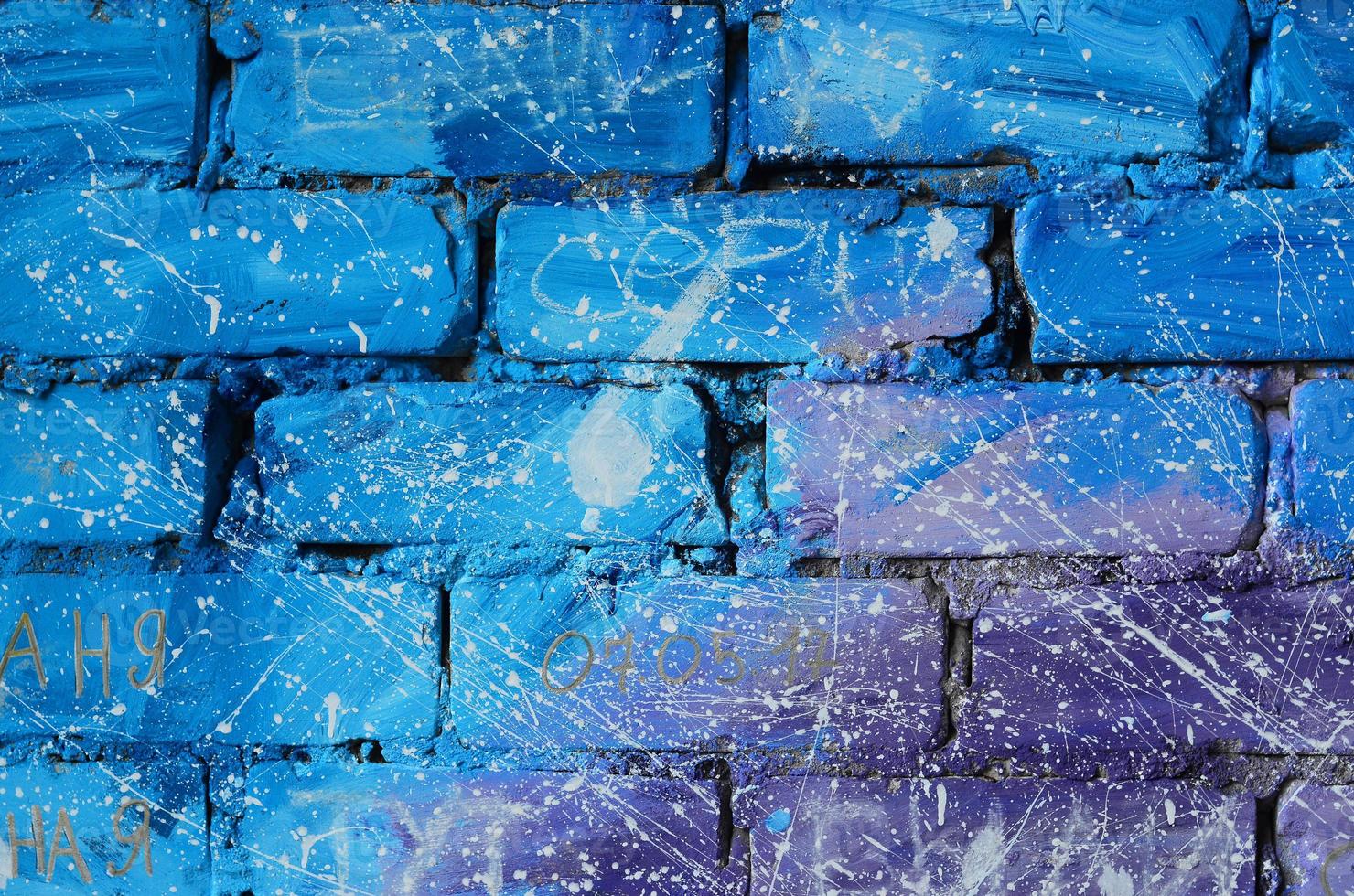 la texture de l'ancien mur de briques, peint en bleu et violet avec des gouttes et des éclaboussures blanches négligemment espacées qui visualisent les étoiles dans l'espace photo