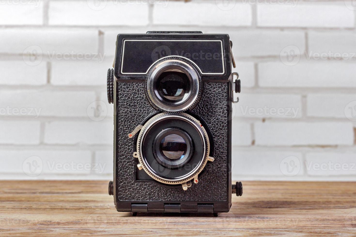 ancien appareil photo retouche vintage sur table en bois. appareil photo rétro avec deux objectifs