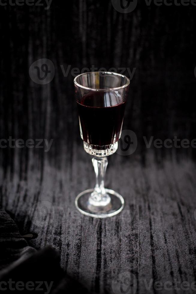 Joli verre de vin rouge sur fond velours noir photo