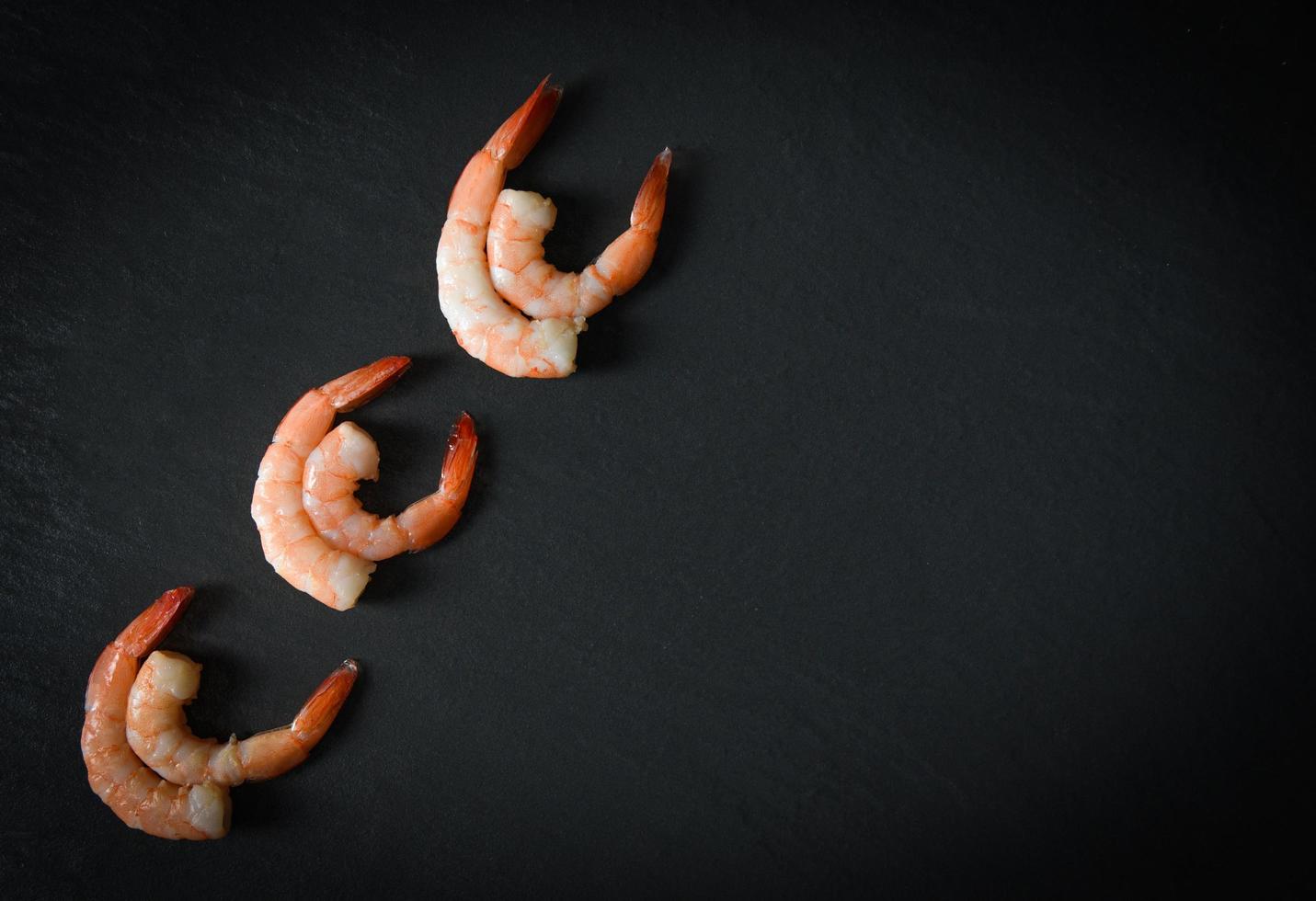 crevettes sur fond sombre fruits de mer crustacés six crevettes bouillies cuites pour la nourriture décorer sur la table le dîner photo