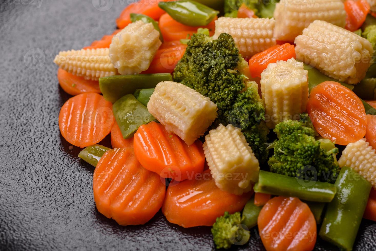 un mélange de légumes carottes, petits épis de maïs, asperges haricots cuits à la vapeur photo