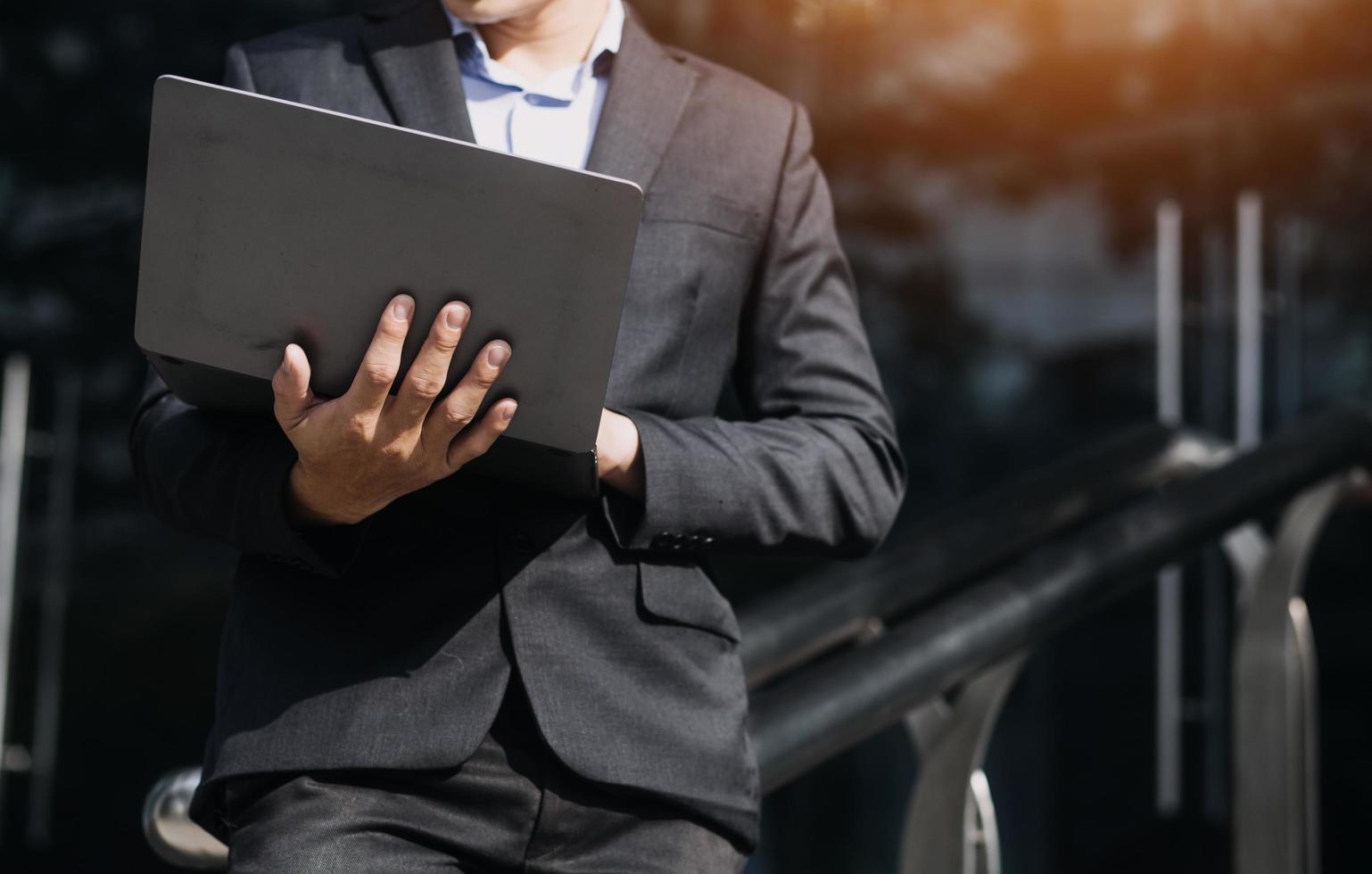 homme d'affaires asiatique et belle jeune femme travaillant sur une tablette numérique debout à l'extérieur de l'immeuble de bureaux. photo