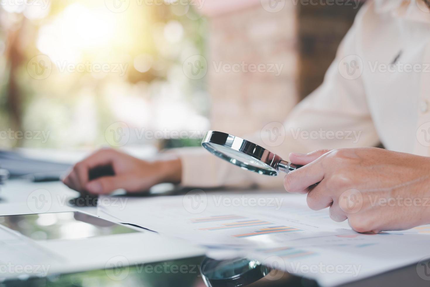 homme d'affaires tenant une loupe, concepts de documents d'audit, gestion de l'évaluation de la qualité avec une liste de contrôle, processus d'évaluation des documents commerciaux, analyse et conseil des rapports sur les données du marché photo