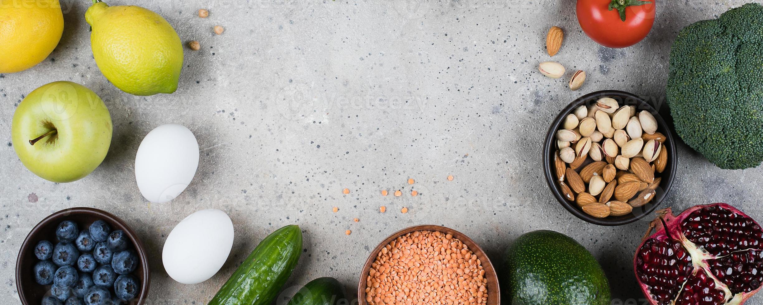 concept de régime alimentaire végétalien sain. légumes verts, tomates, noix, fruits, lentilles, pois chiches, verts sur fond de table en béton gris. mise à plat, vue de dessus. cadre alimentaire, image de bannière photo