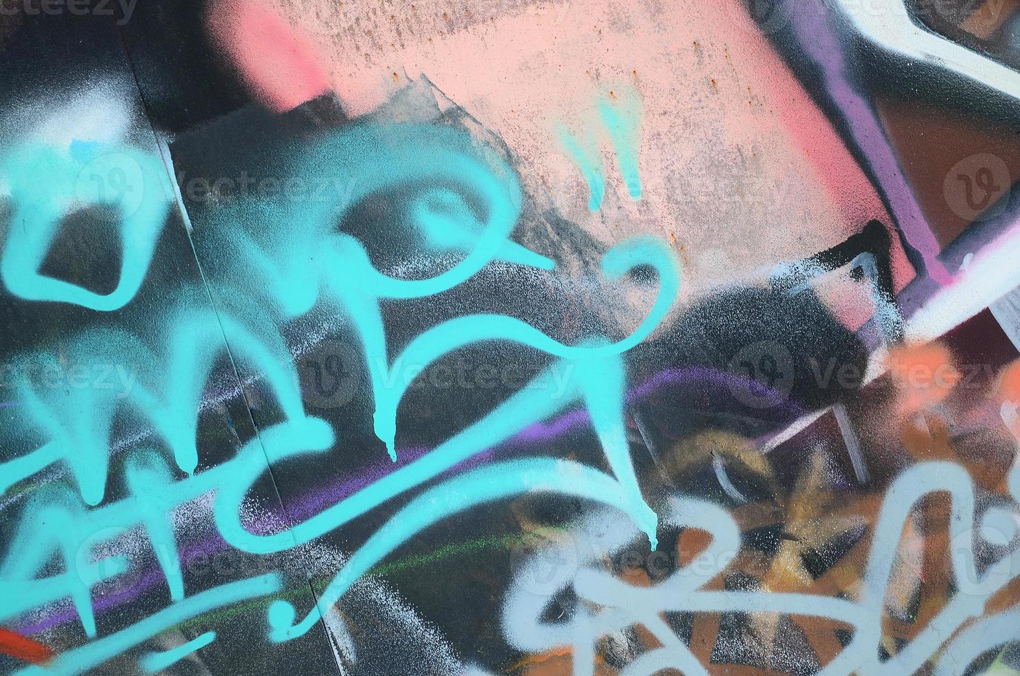 fragment en gros plan d'un dessin de graffiti appliqué au mur par de la peinture aérosol. le mur est gâché par une multitude de signatures colorées et de tags d'artistes de rue et de hooligans photo