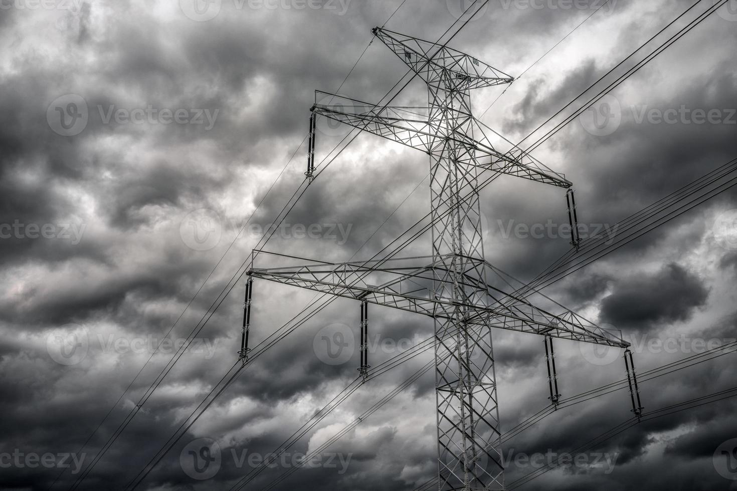 pôle haute tension et nuages sombres sur le ciel photo