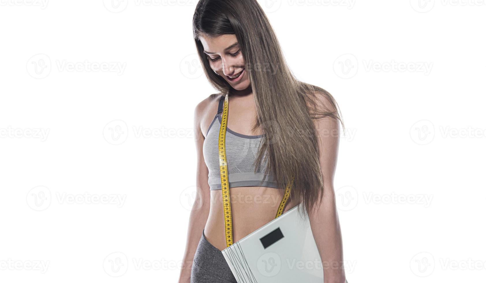 femme mince heureuse satisfaite de ses résultats de régime tenant un pèse-personne photo