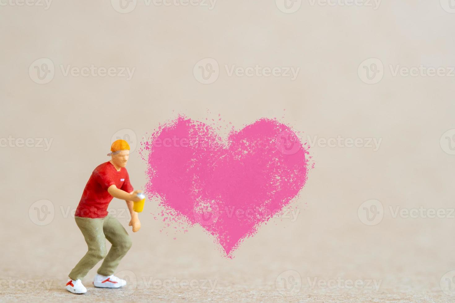 artiste tenant un distributeur et pulvérisant avec des formes de coeur rouge, concept de la Saint-Valentin photo