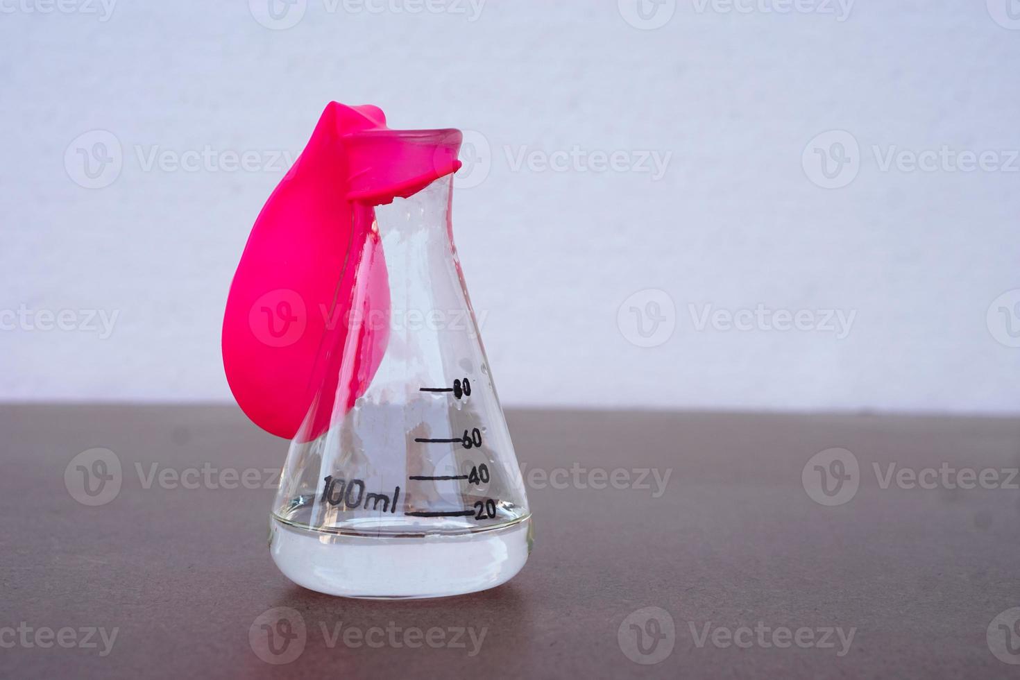 expérience scientifique, ballon rose plat sans air au-dessus d'une bouteille de test transparente. première étape de l'expérience sur la réaction de l'air ou du gaz. en utilisant du bicarbonate de soude et du vinaigre. concept, enseignement des sciences photo