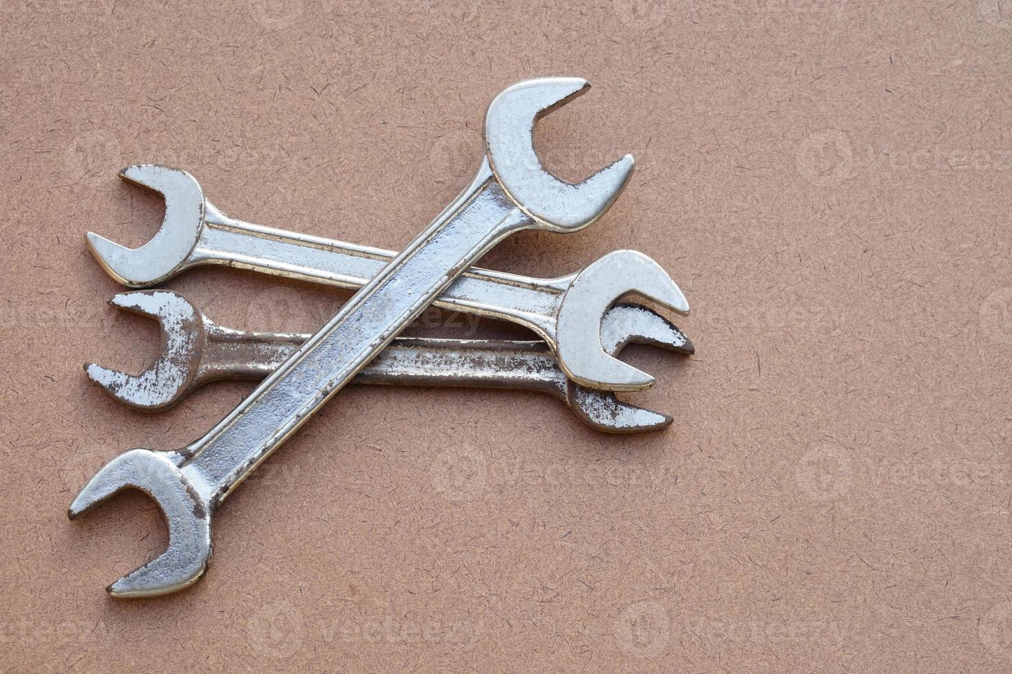 jeu de clés métalliques isolées sur marron. concept, bricoleur, outils mécaniques. clés. matériel de fixation ou de réparation, rénovation dans la vie quotidienne. photo