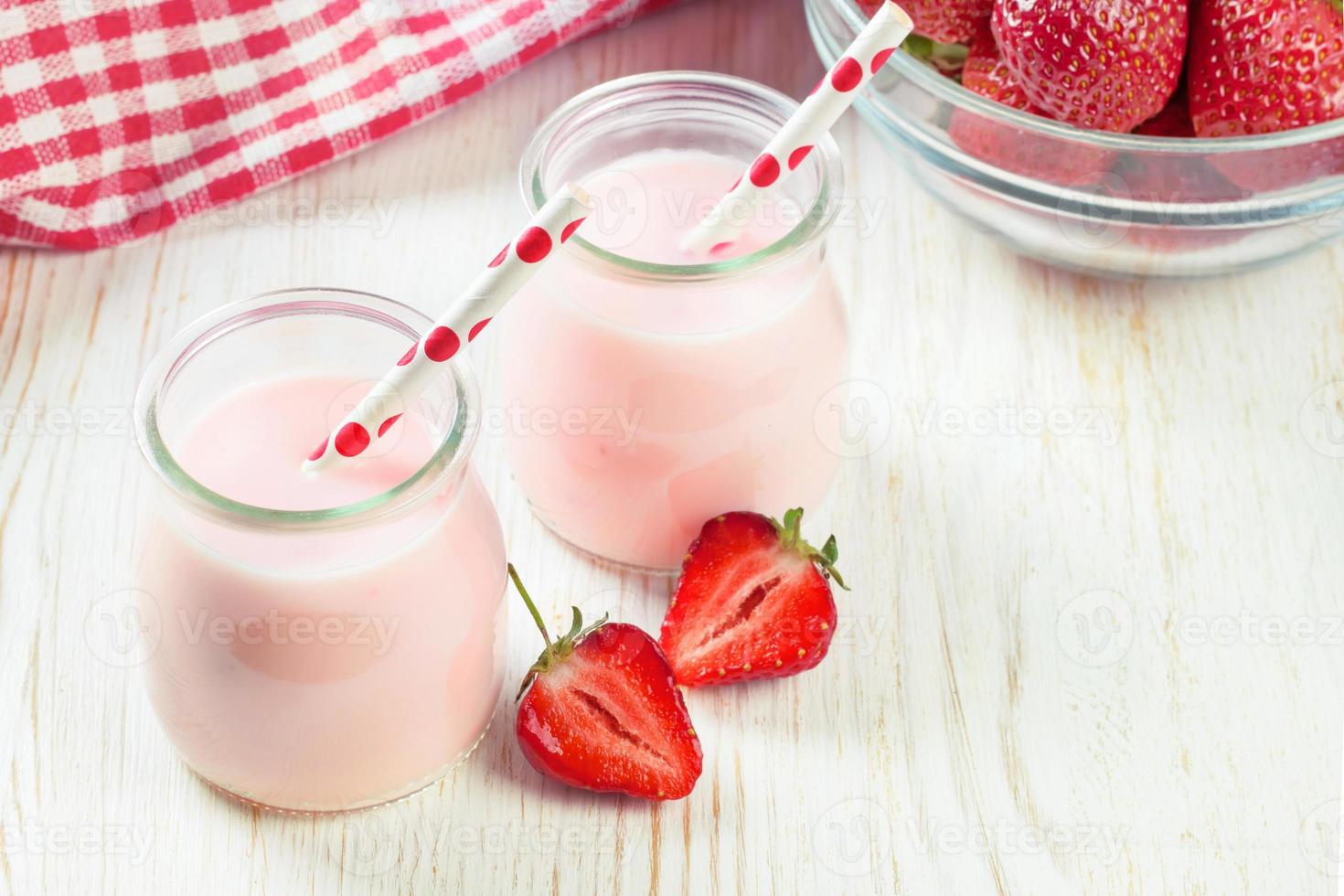 milk-shake aux fraises dans le bocal en verre sur fond de bois blanc photo