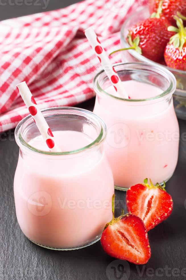 milk-shake aux fraises dans le bocal en verre sur fond d'ardoise noire photo