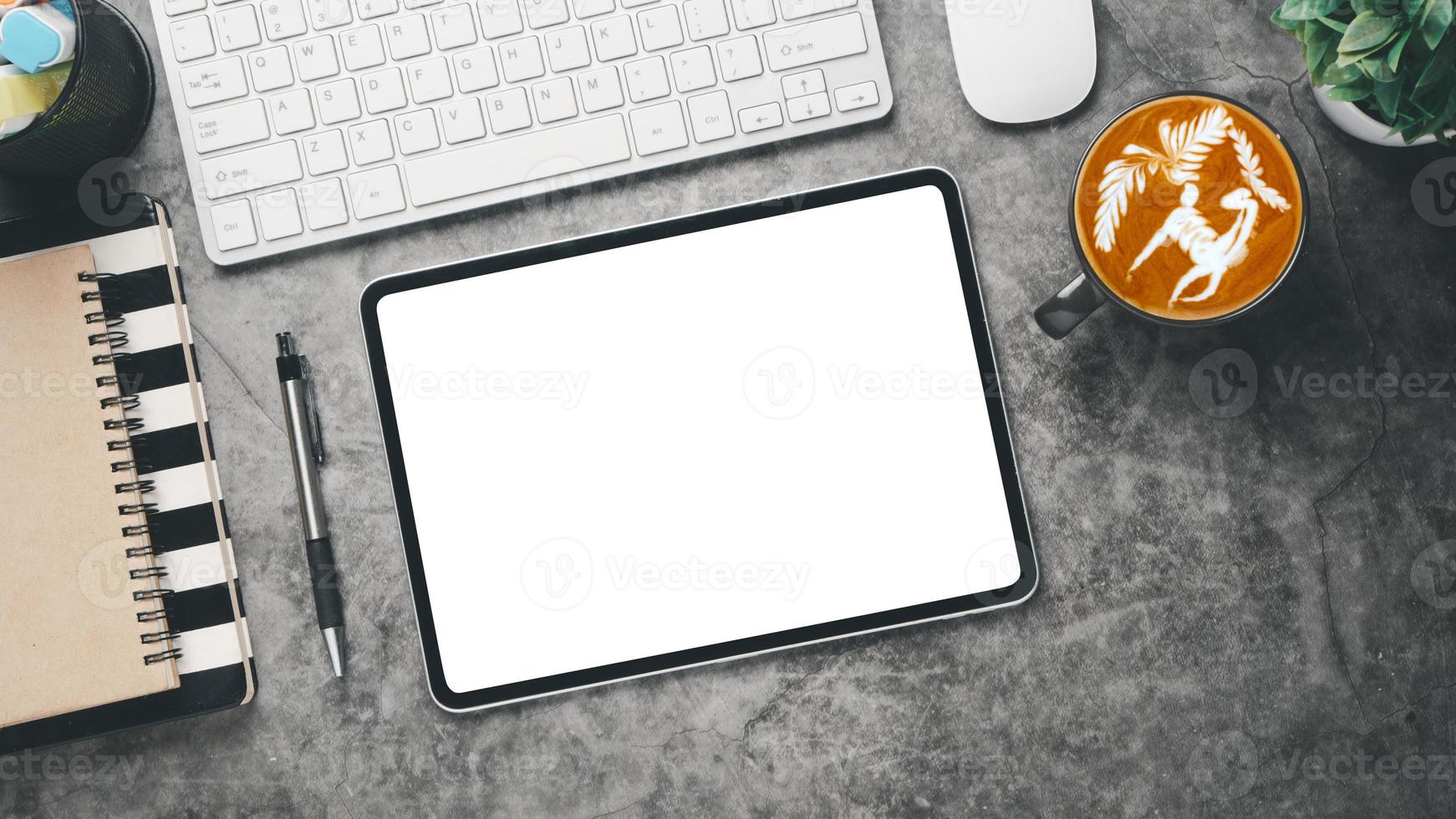 lieu de travail de bureau avec tablette à écran vierge, ordinateur portable, clavier, souris, stylo et tasse de café, vue de dessus à plat. photo