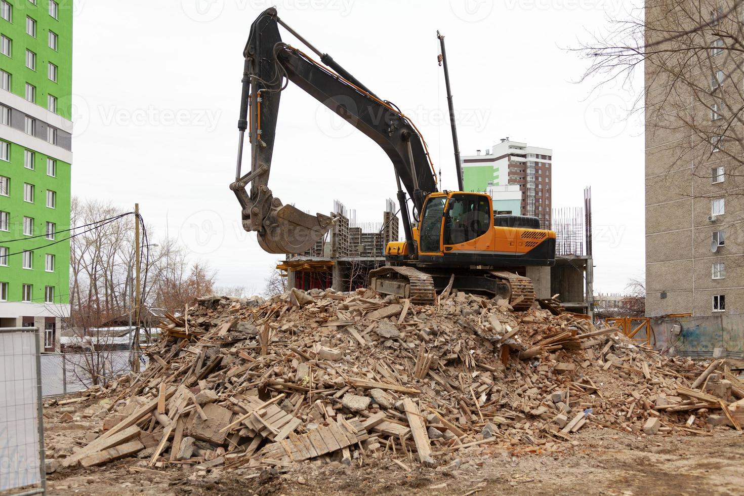 démolition d'un vieux bâtiment par une excavatrice moderne photo