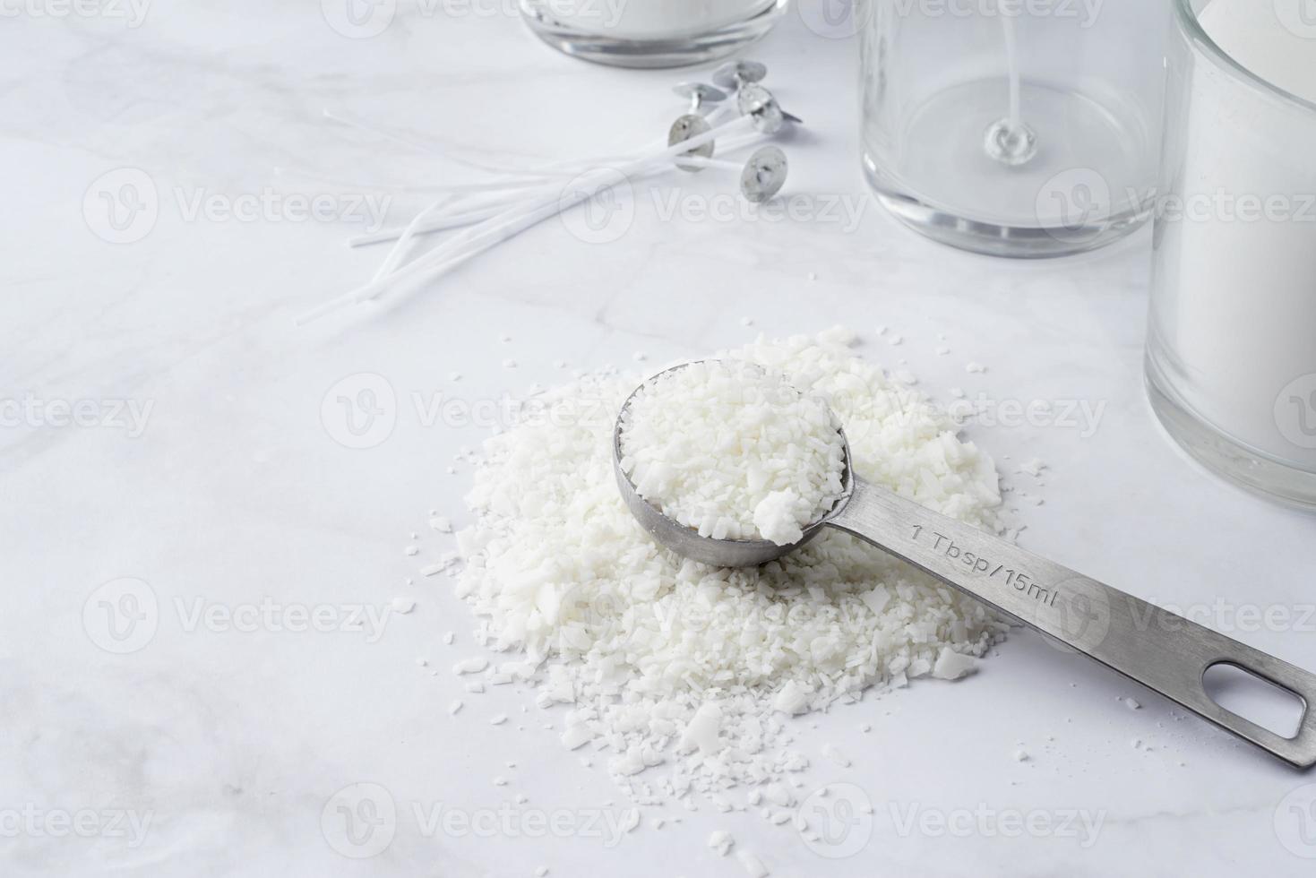 ingrédients pour la fabrication de bougies, flocons de cire de soja, bougies, mèches sur fond de marbre clair photo