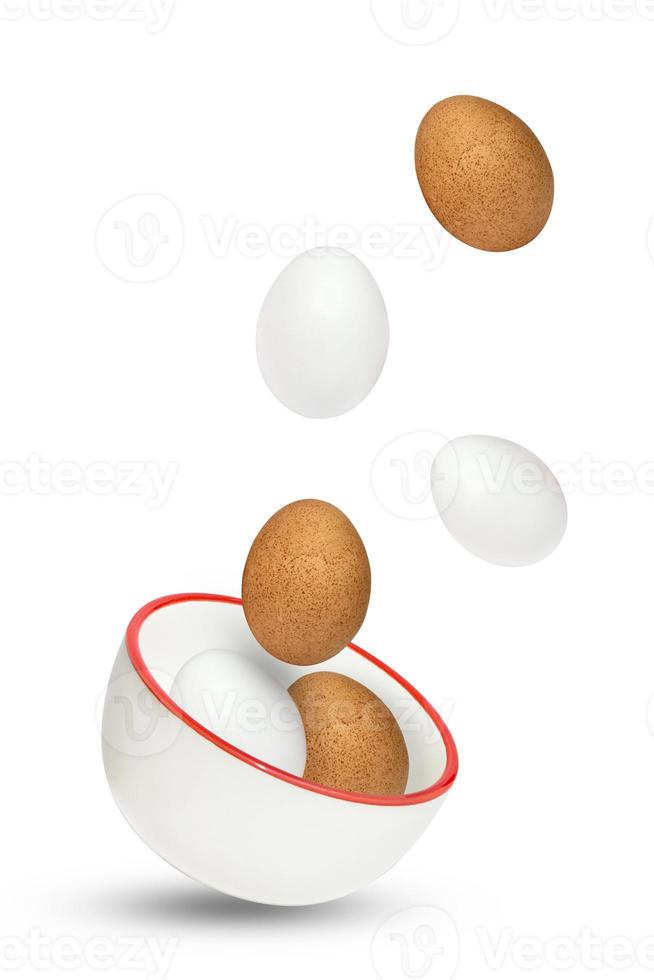 oeufs jetés en l'air à partir d'un bol en céramique. ingrédients culinaires. oeufs de poule de pâques isolés sur fond blanc avec des ombres ajoutées photo