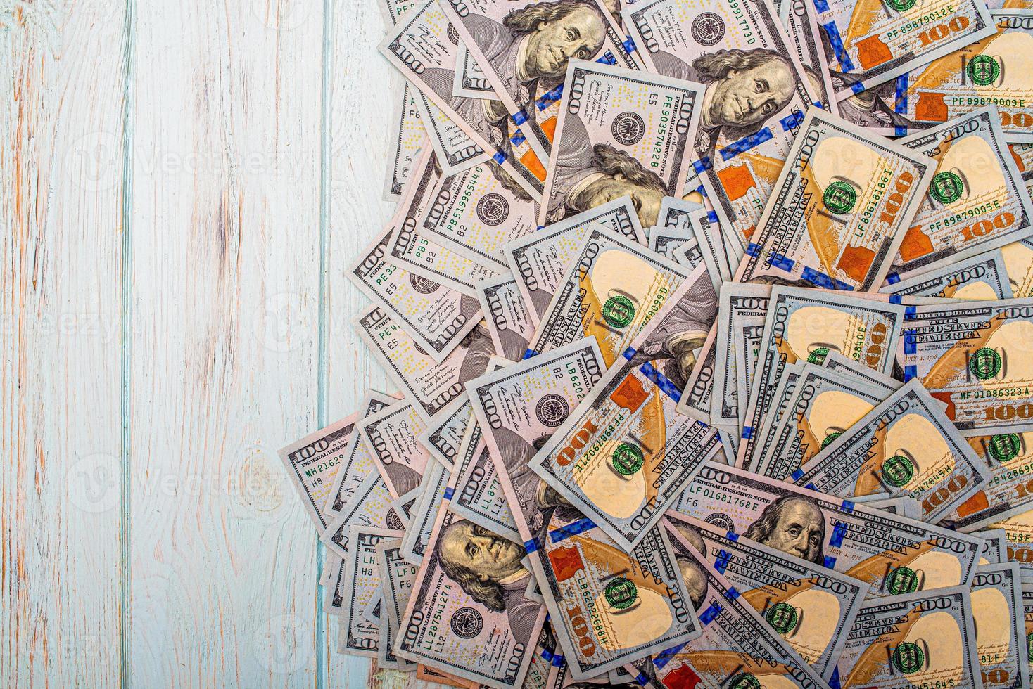 billets de cent dollars sur fond bleu. monnaie américaine sur un fond en bois. photo