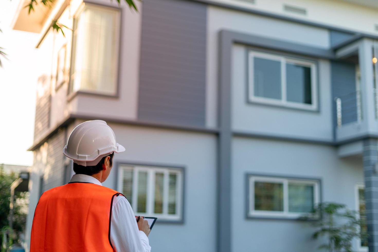 l'inspecteur ou l'ingénieur vérifie et inspecte le bâtiment ou la maison à l'aide d'une liste de contrôle. ingénieurs et architectes travaillent à la construction de la maison avant de la remettre au propriétaire. photo