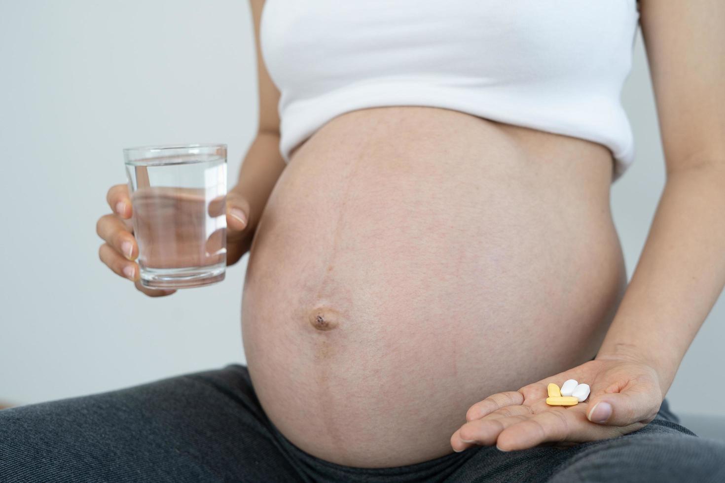 les femmes enceintes consomment des vitamines et des foliques pour nourrir la grossesse. grossesse saine pour bébé. photo