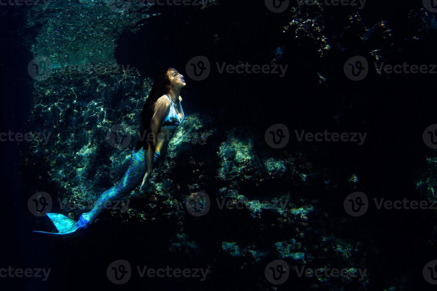 sirène nageant sous l'eau dans l'océan d'un bleu profond photo