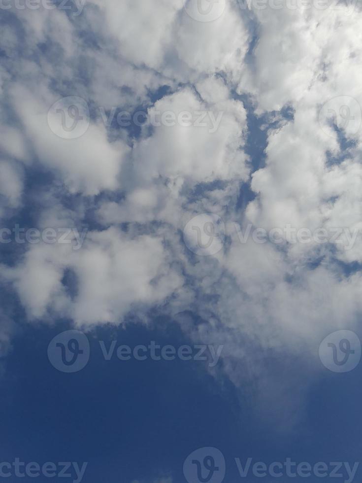 beaux nuages blancs sur fond de ciel bleu profond. image élégante de ciel bleu à la lumière du jour. de grands nuages doux et moelleux couvrent tout le ciel bleu. photo