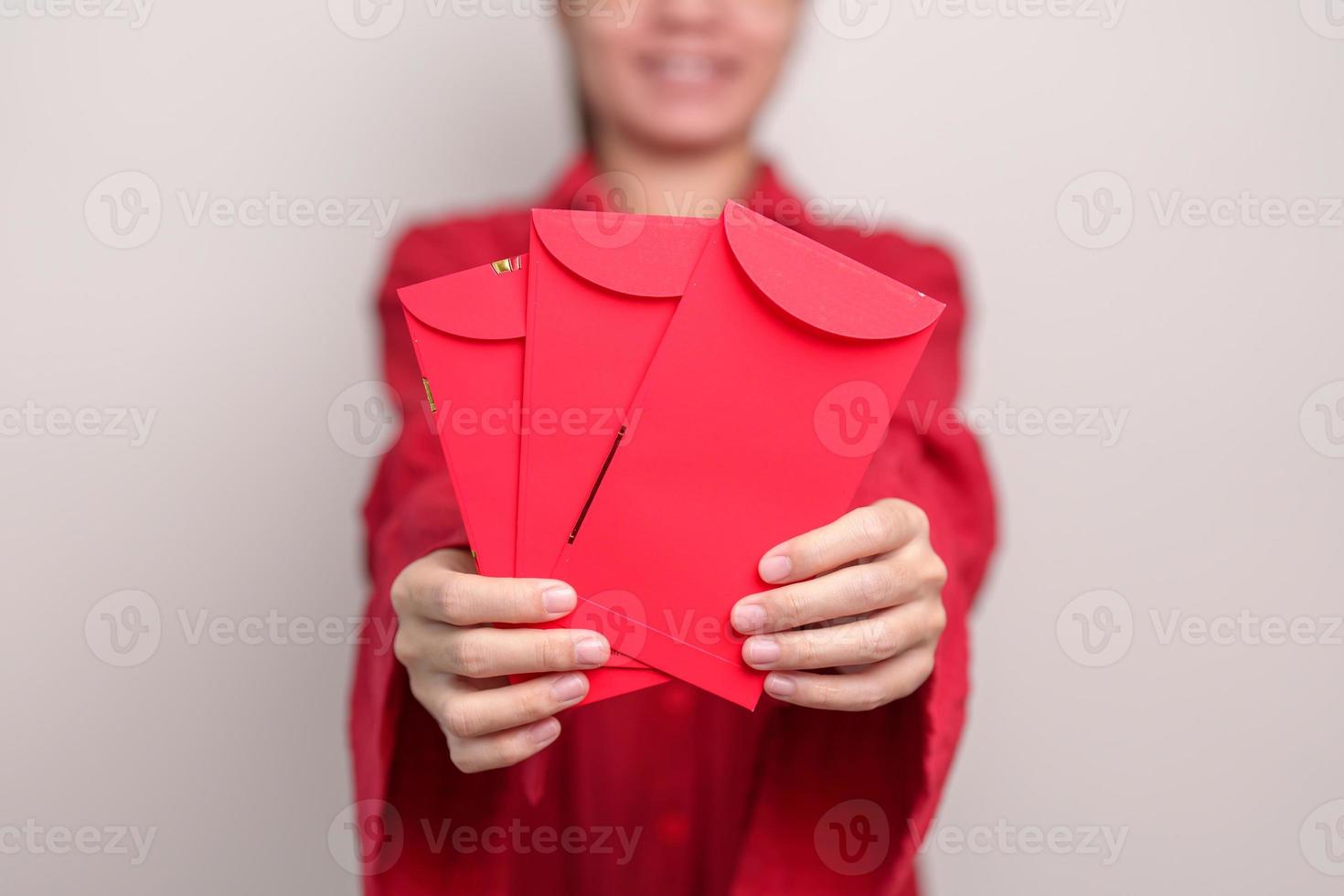 femme tenant une enveloppe rouge chinoise, cadeau en argent pour les vacances du nouvel an lunaire photo