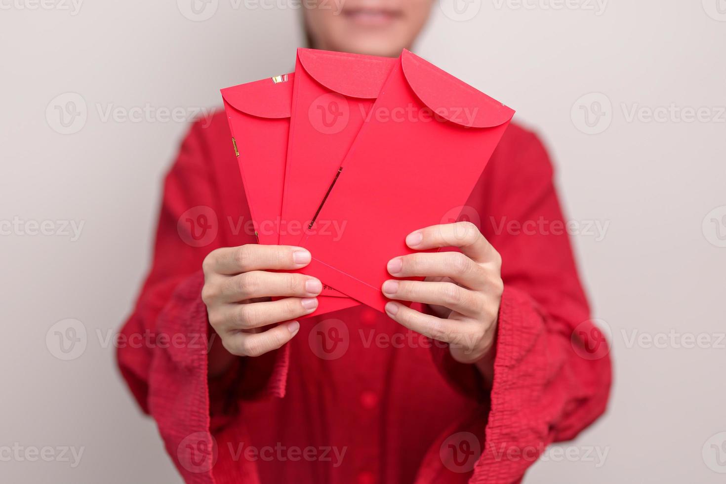 femme tenant une enveloppe rouge chinoise, cadeau en argent pour les vacances du nouvel an lunaire photo