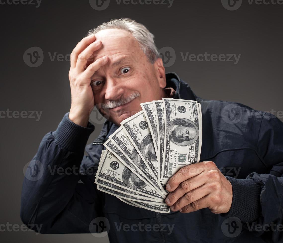 vieil homme tenant un groupe de billets d'un dollar photo