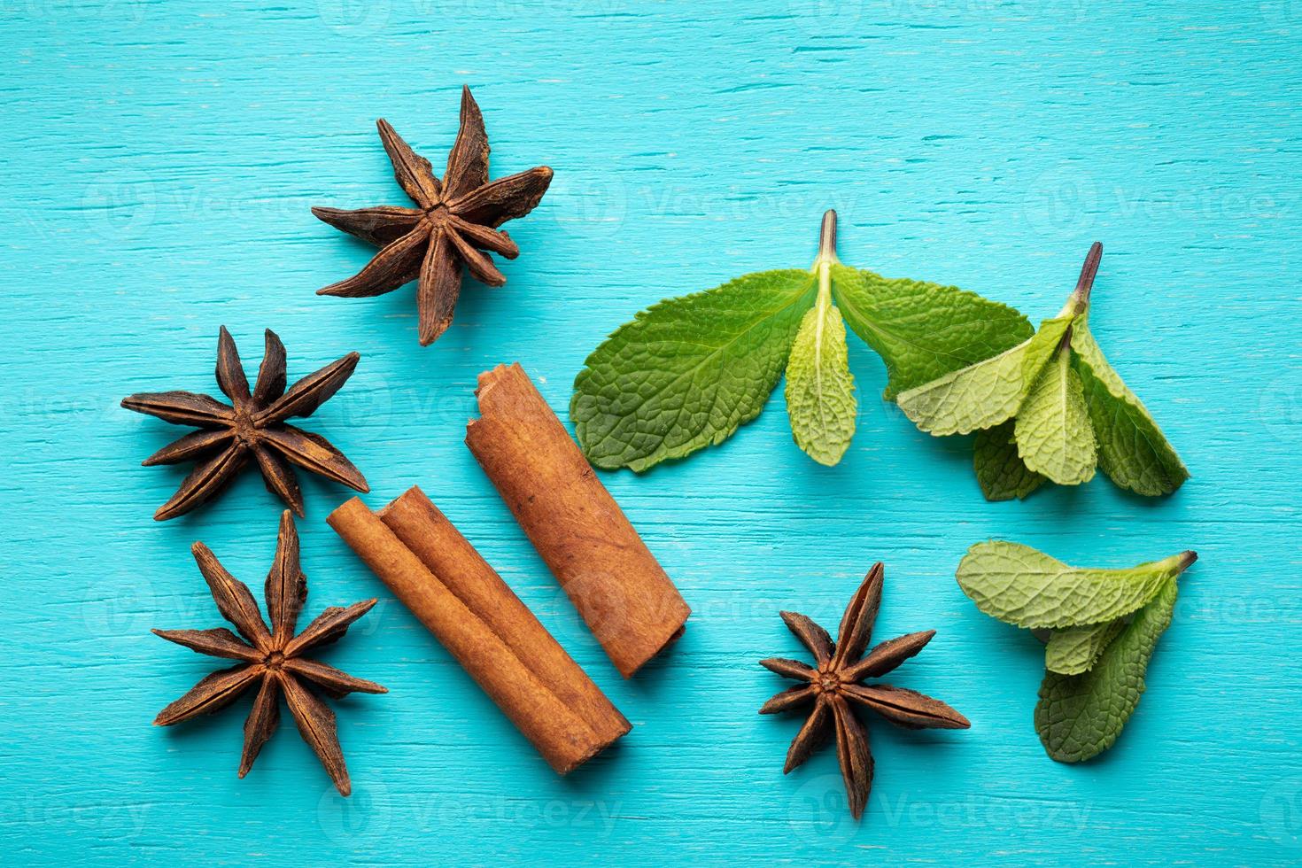 bâtons de cannelle avec des étoiles de menthe et d'anis sur fond turquoise. photo