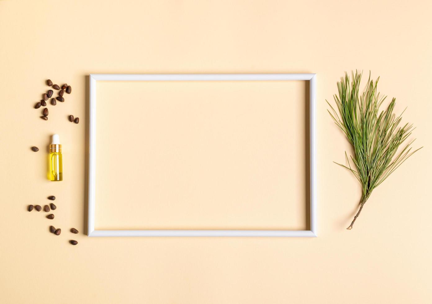 cadre vide blanc et petite bouteille en verre avec huile essentielle de cèdre aromatique spa conifère, branche, noix autour d'elle. photo