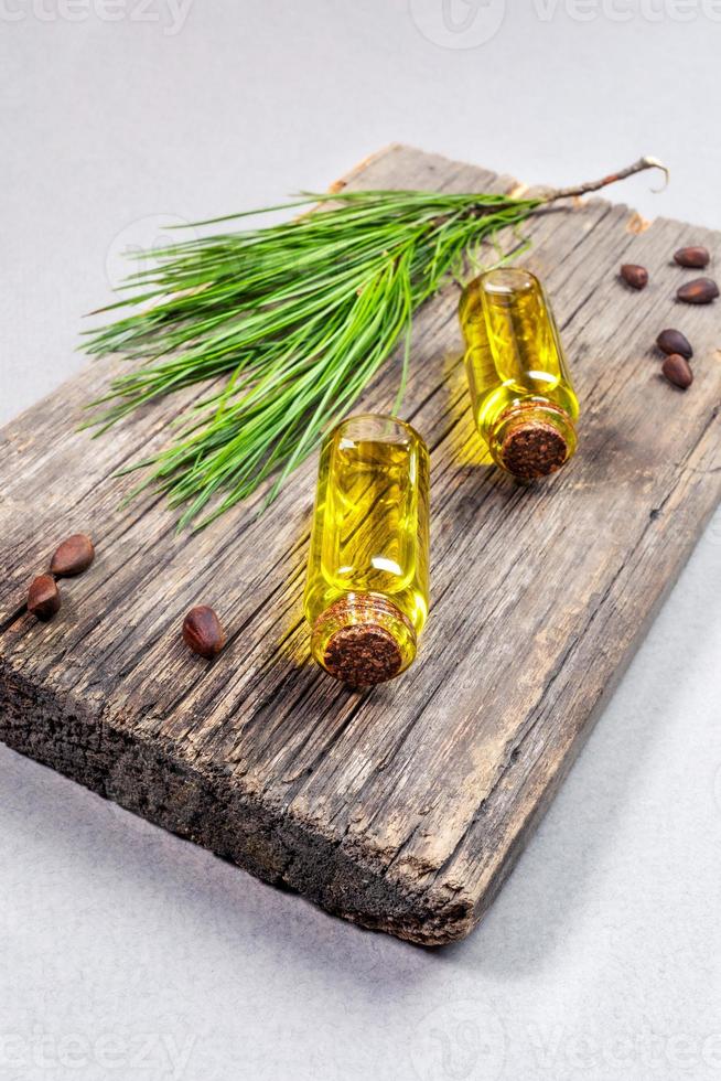 produits de spa et concept d'aromathérapie conifère avec de petites bouteilles en verre d'huile essentielle de cèdre sur une vieille planche de bois. photo