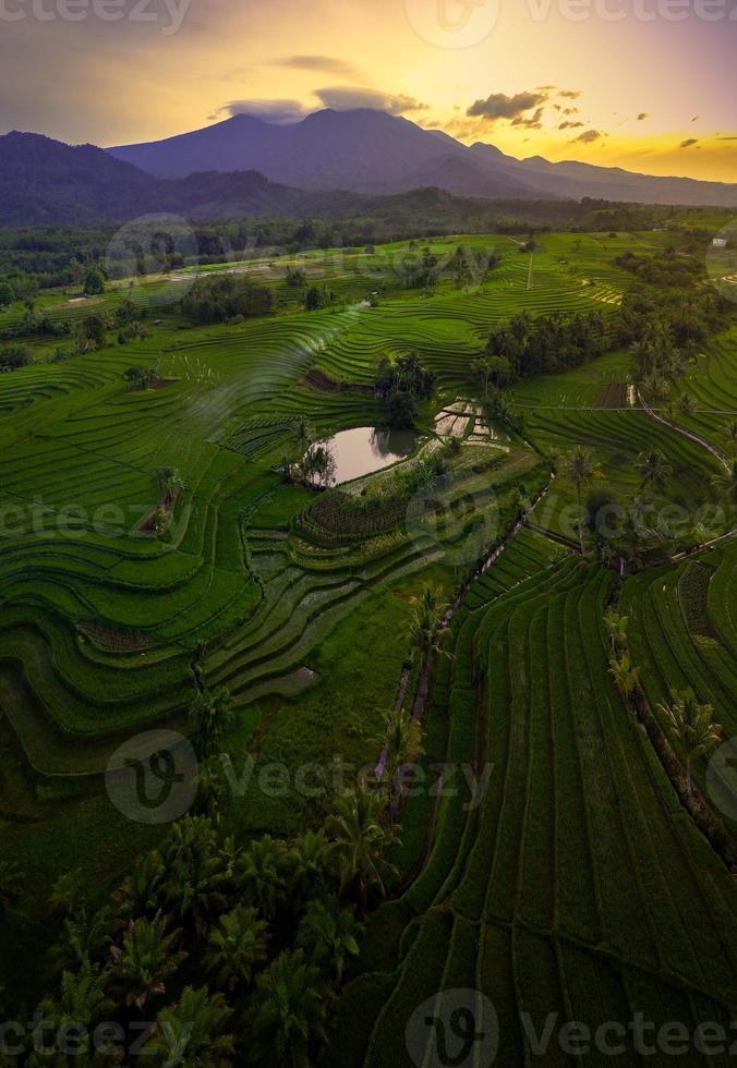 vue aérienne de la zone rurale indonésienne avec montagnes et rizières le matin photo