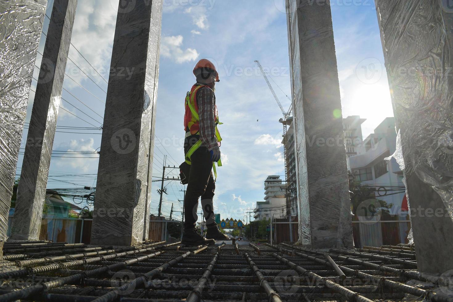 travailleur portant un harnais de sécurité et une ligne de sécurité travaillant en hauteur travail sur chantier concepts de bâtiment résidentiel en construction photo